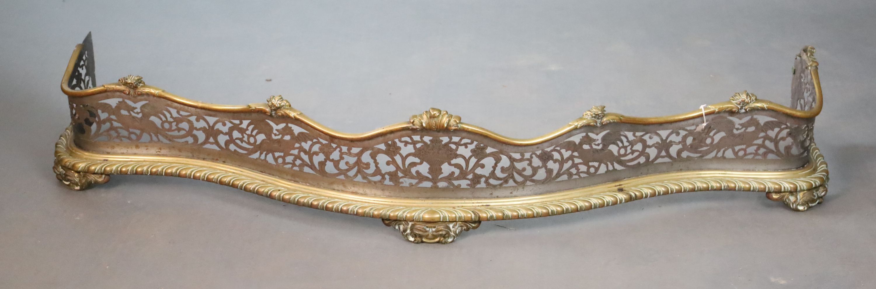 A George III brass and steel fender and pair of fire dogs